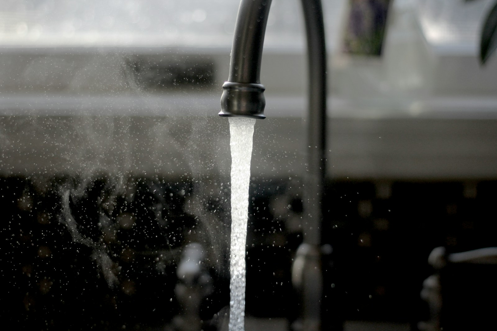 Water running from a kitchen faucet into a sink